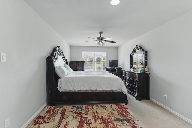 bedroom featuring light colored carpet, baseboards, and ceiling fan