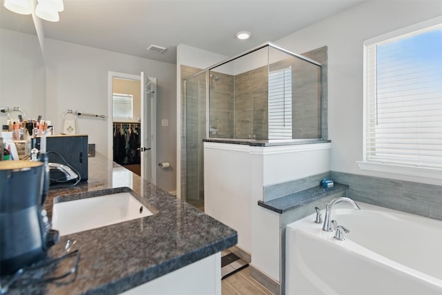 bathroom with vanity, visible vents, a stall shower, a spacious closet, and a bath