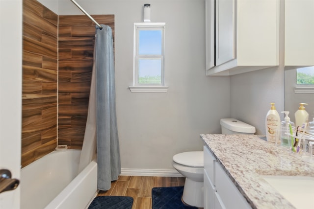 bathroom with toilet, wood finished floors, vanity, shower / bath combination with curtain, and baseboards