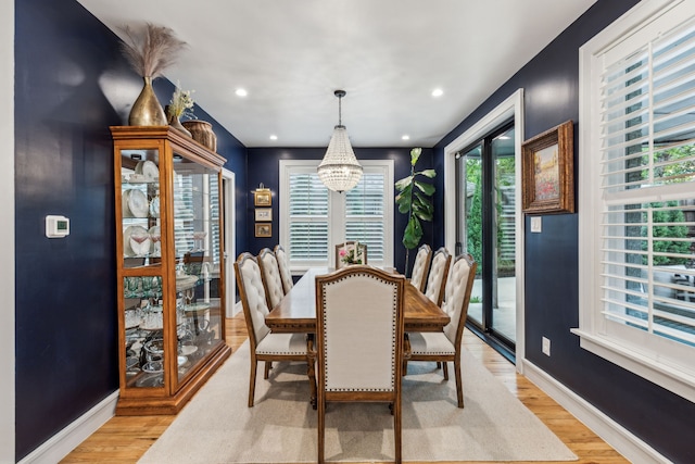 dining space featuring a chandelier, light wood-type flooring, baseboards, and recessed lighting