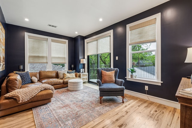 living room featuring baseboards, wood finished floors, visible vents, and recessed lighting