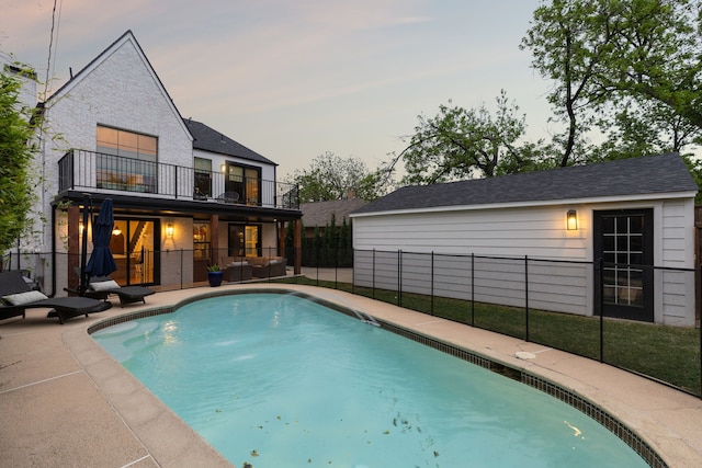 rear view of property with a patio, fence, a balcony, and a fenced in pool