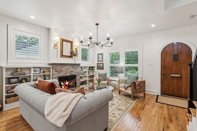 living room with recessed lighting, a chandelier, wood finished floors, and a fireplace