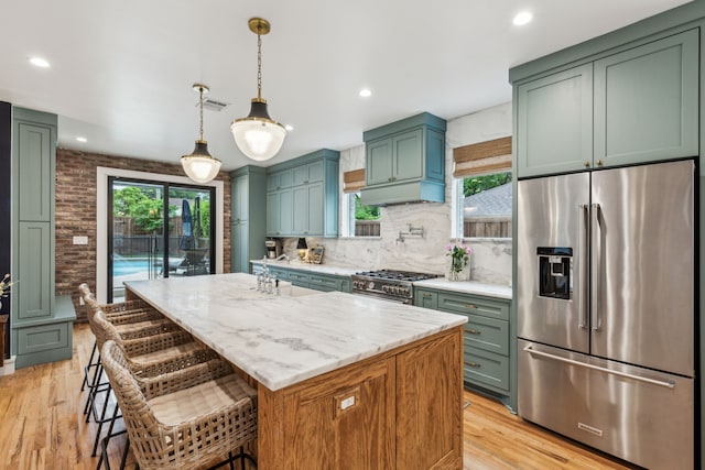kitchen featuring visible vents, light stone countertops, light wood-style flooring, tasteful backsplash, and appliances with stainless steel finishes