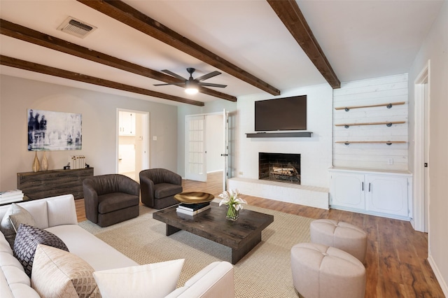 1904 Park Hill Dr, Arlington, TX 76012 - living area with wood finished floors, a ceiling fan, a brick fireplace, and beam ceiling