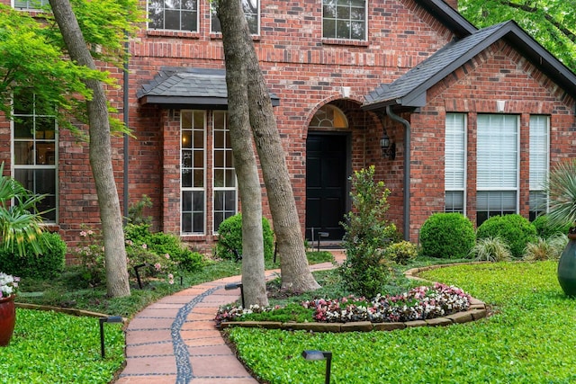 view of exterior entry with brick siding