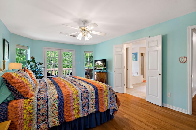 bedroom with baseboards, wood finished floors, access to outside, and multiple windows