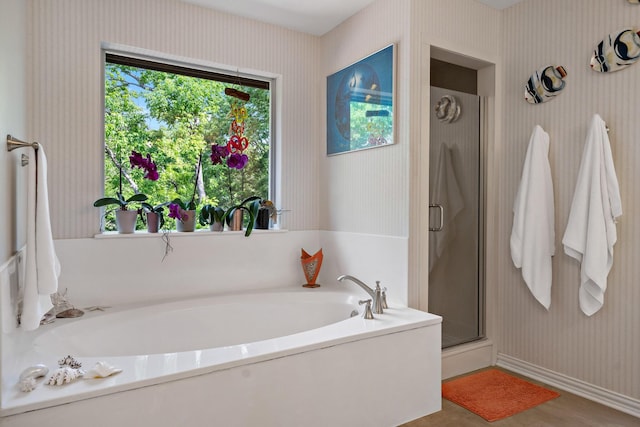 full bathroom featuring wallpapered walls, a shower stall, baseboards, and a bath