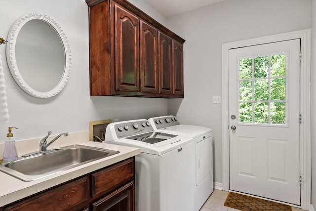 washroom featuring light tile patterned floors, cabinet space, a sink, and independent washer and dryer