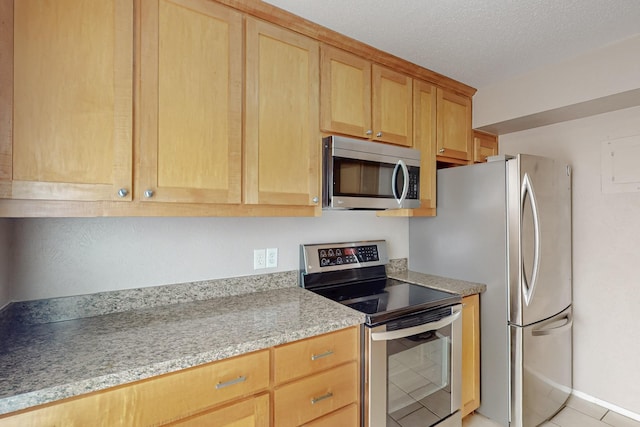 kitchen with light countertops, stainless steel appliances, and light tile patterned floors