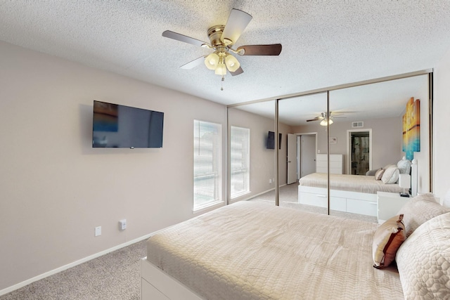 bedroom with a textured ceiling, ceiling fan, light carpet, baseboards, and visible vents