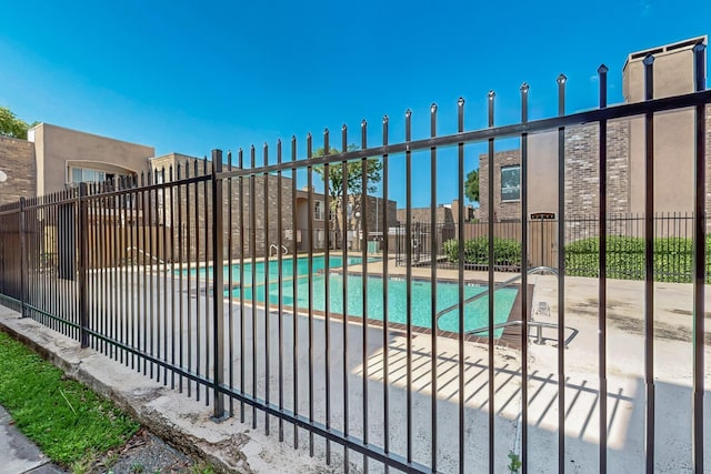 community pool featuring fence and a patio
