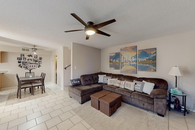 living area featuring light tile patterned flooring, a textured ceiling, and a ceiling fan