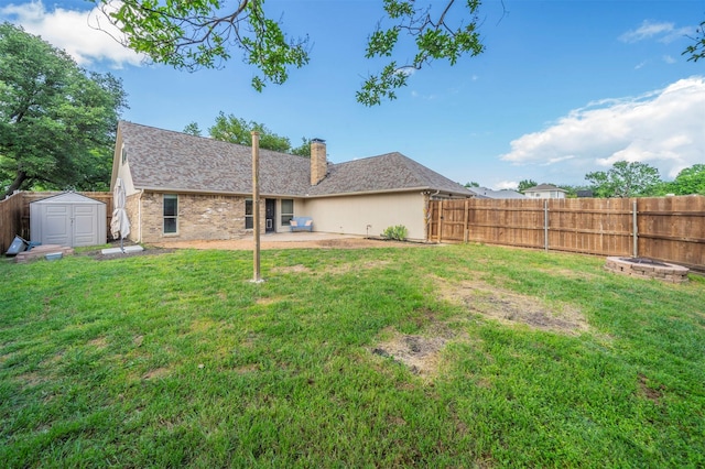back of property with a chimney, a fenced backyard, a yard, a shed, and a patio