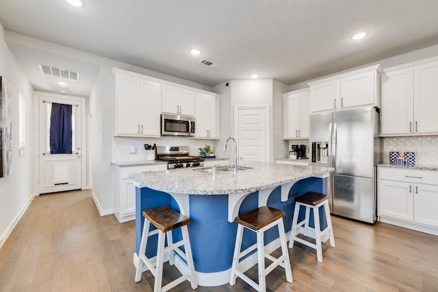 1008 Shire Dr, Aubrey, TX 76227 - kitchen with a sink, stainless steel appliances, light wood-type flooring, visible vents, and decorative backsplash