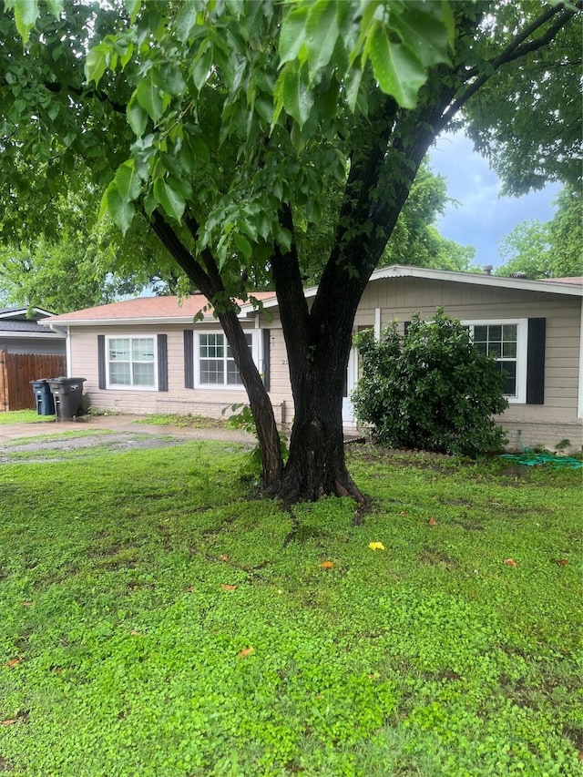 view of home's exterior featuring fence, brick siding, and a yard