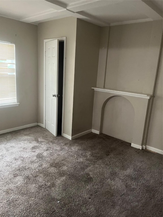 unfurnished living room featuring carpet floors and baseboards