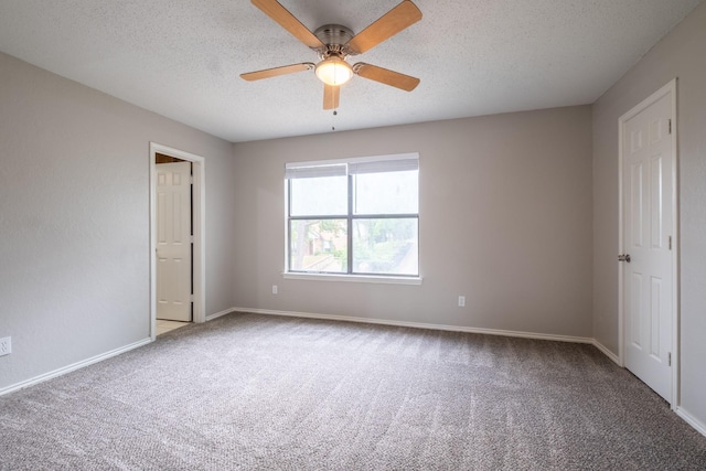 unfurnished bedroom featuring ceiling fan, carpet floors, a textured ceiling, and baseboards