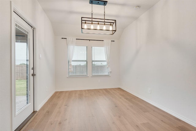 unfurnished dining area featuring baseboards and light wood finished floors