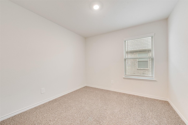 carpeted spare room featuring baseboards