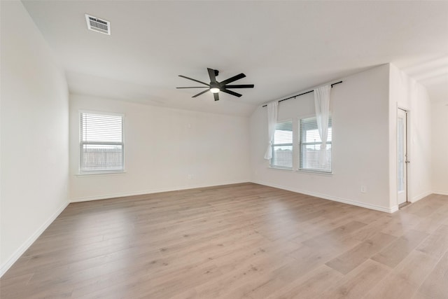 spare room with visible vents, ceiling fan, light wood-style flooring, and baseboards