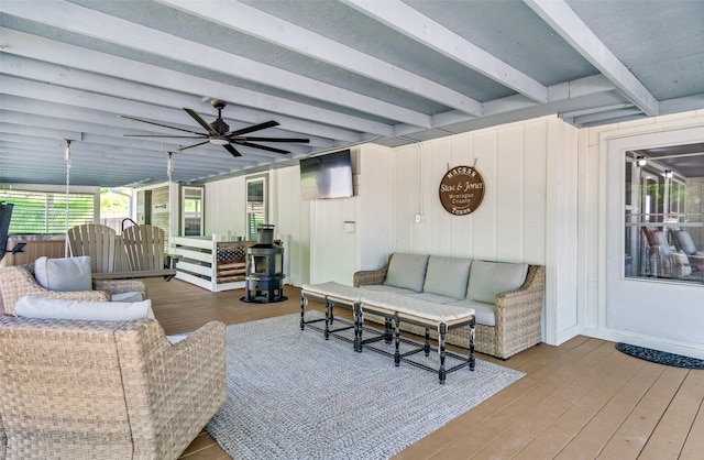 living room featuring a ceiling fan, beam ceiling, and wood finished floors