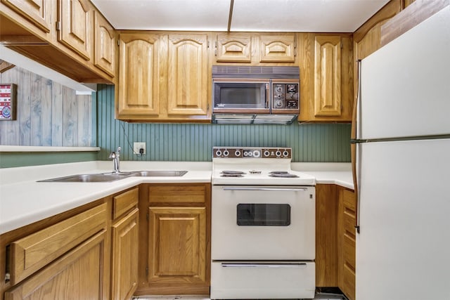 kitchen featuring a sink, white appliances, and light countertops
