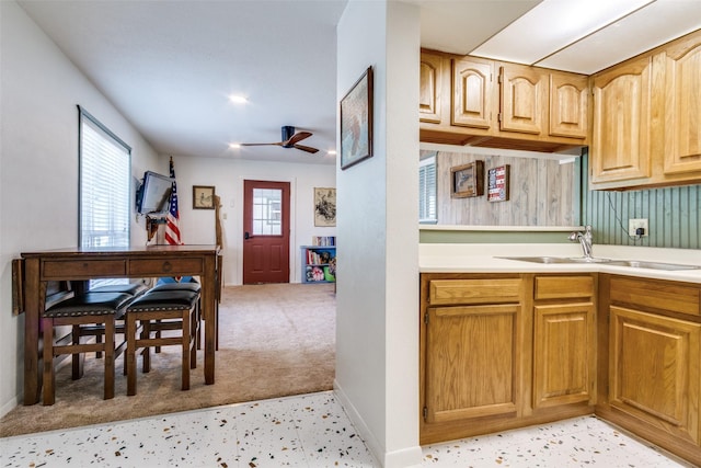 kitchen with a ceiling fan, baseboards, and light countertops