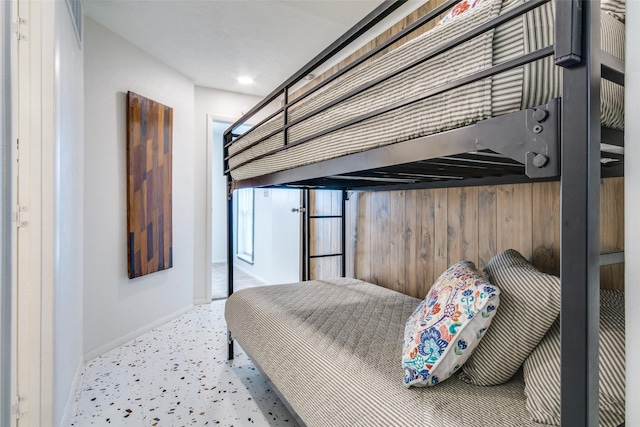 bedroom with wooden walls and baseboards