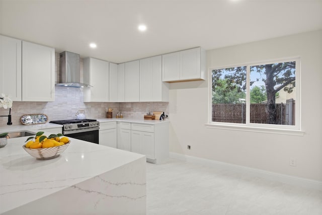 1925 Berkner Dr, Richardson, TX 75081 - kitchen featuring wall chimney range hood, stainless steel range with gas cooktop, a sink, light stone countertops, and decorative backsplash
