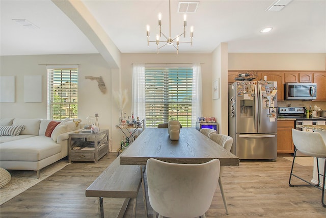 dining space featuring recessed lighting, light wood-style floors, visible vents, and a notable chandelier