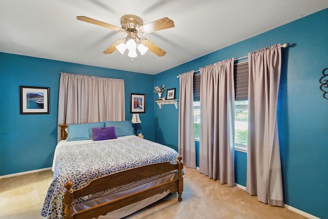 bedroom featuring light carpet, baseboards, and ceiling fan