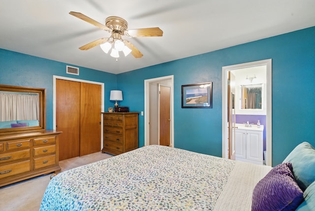bedroom featuring ensuite bathroom, visible vents, light colored carpet, a closet, and ceiling fan