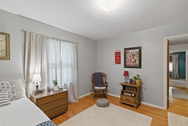 bedroom featuring light wood-style floors and baseboards