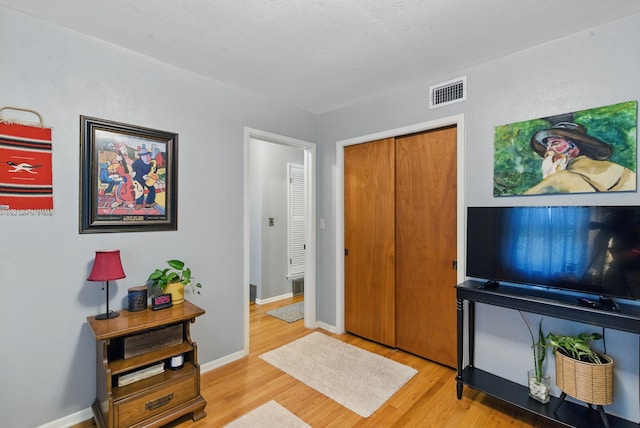 foyer entrance featuring light wood-type flooring, baseboards, and visible vents