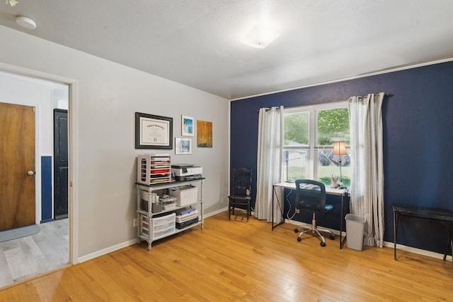 office space with baseboards and light wood-style floors