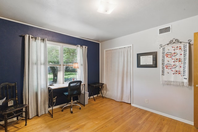 office with light wood-type flooring, visible vents, and baseboards
