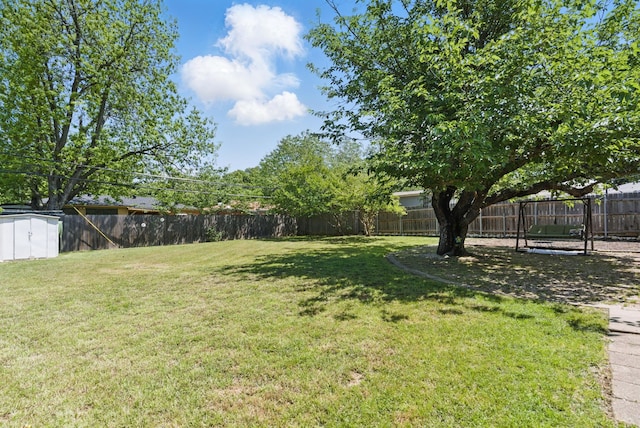 view of yard with a fenced backyard, an outbuilding, and a storage shed