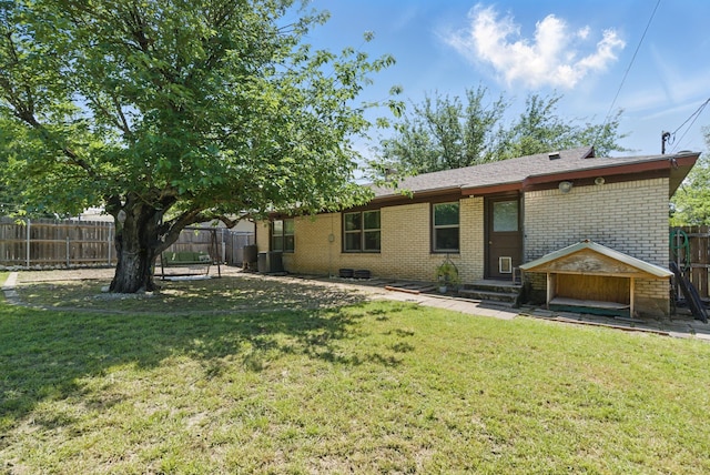 rear view of property with entry steps, a fenced backyard, and brick siding