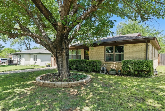 ranch-style house with brick siding, a front lawn, and fence