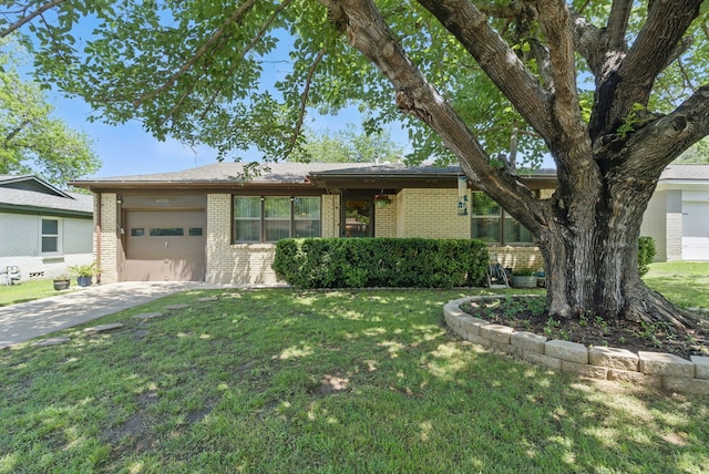 view of front of house with an attached garage, driveway, brick siding, and a front yard