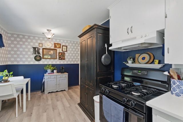 6050 Douglas St, Fort Worth, TX 76114 - kitchen with black range with gas stovetop, wallpapered walls, under cabinet range hood, light wood-style flooring, and light countertops