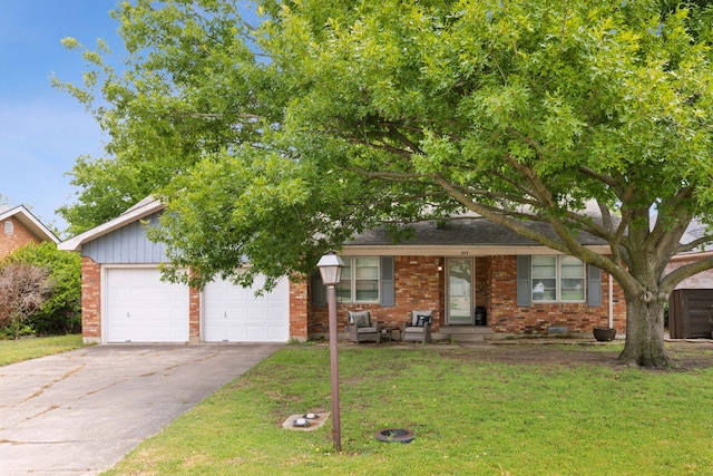view of property hidden behind natural elements featuring concrete driveway, brick siding, a garage, and a front yard
