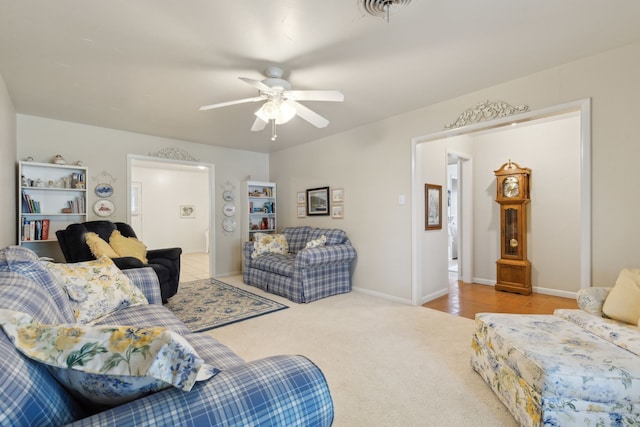 living room featuring ceiling fan, baseboards, and carpet flooring