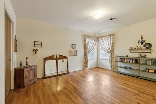 interior space featuring visible vents, baseboards, and wood finished floors
