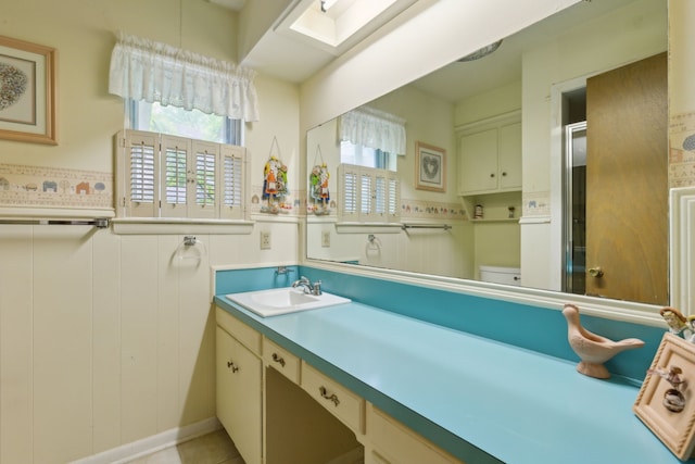 full bath featuring a skylight, vanity, and toilet