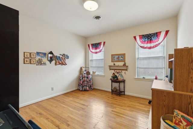 interior space featuring light wood-style floors, visible vents, and baseboards
