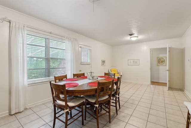 dining space featuring plenty of natural light, baseboards, and light tile patterned floors