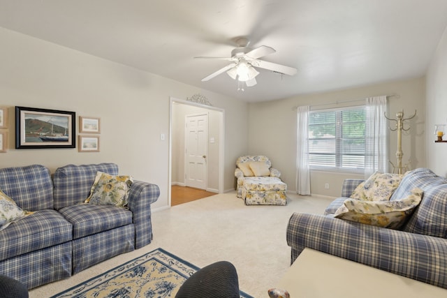 carpeted living area featuring a ceiling fan and baseboards