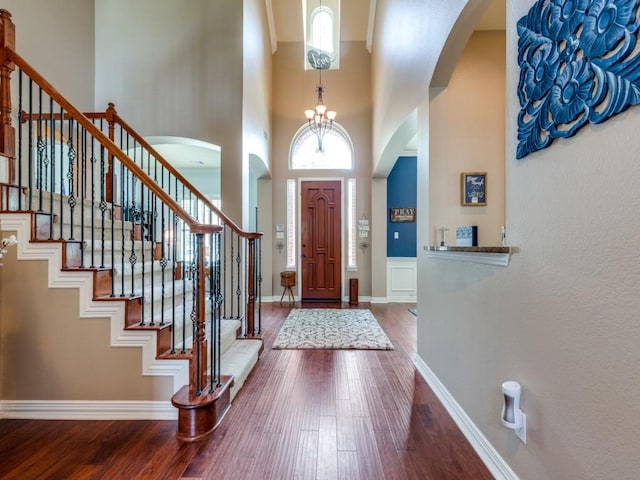 3226 Appleblossom Dr, Frisco, TX 75033 - entryway with dark wood finished floors, stairs, arched walkways, a chandelier, and a high ceiling